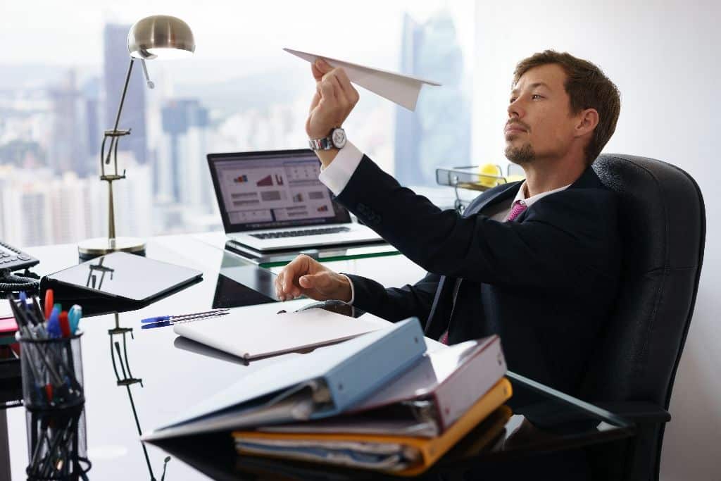 SME employee overwhelmed by paperwork, reducing productivity and wasting valuable business time