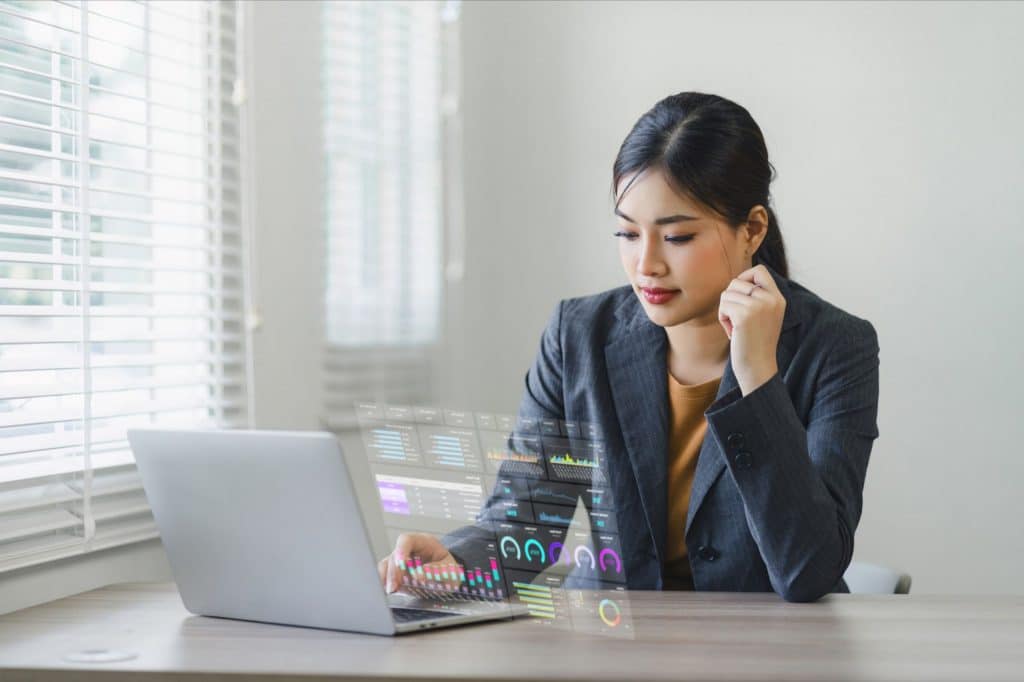 AI staff augmentation specialist reviewing delivery dashboards on laptop